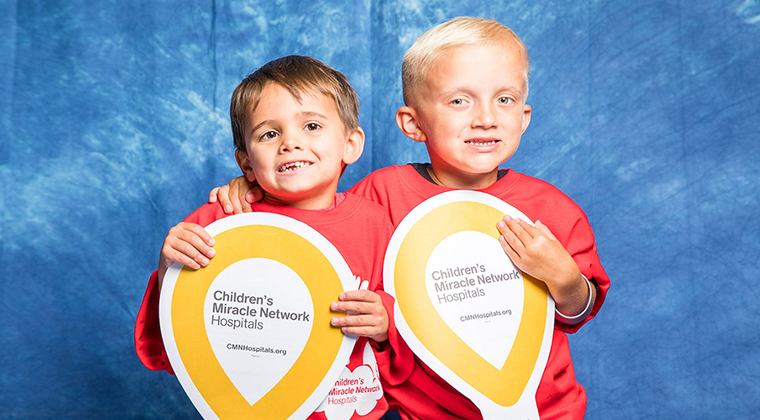 Two young boys holding CMN Hospitals Miracle Balloons