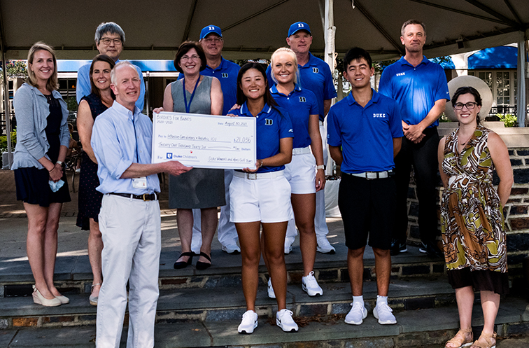 A check presentation featuring members of the Duke Golf Teams and pediatric care providers. 