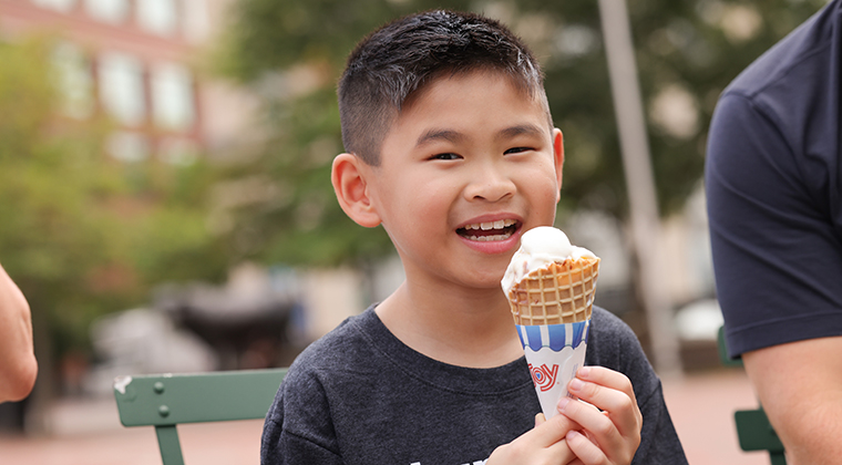 Photo of Zach, a 9-year-old Asian boy, eating an ice cream cone. 