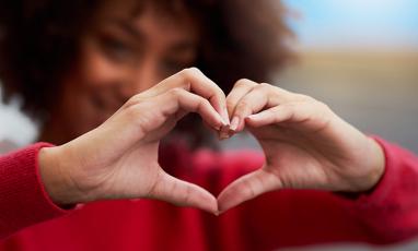A woman holding her hands in the shape of a heart