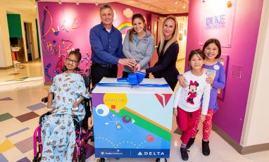 Kids and adults around a colorful cart