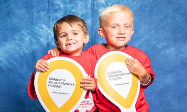 Two young boys holding CMN Hospitals Miracle Balloons
