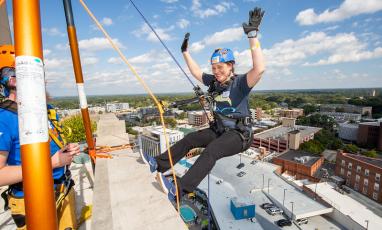 A woman rappels off the side of 21c Museum Hotel in downtown Durham. 