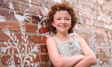 A photo of Harper, a 10-year-old white girl with curly red hair.